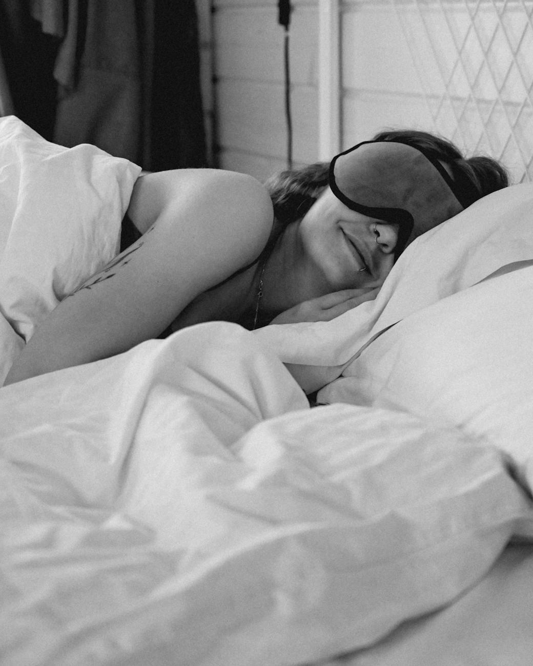 woman sleeping in bed with sleeping mask on