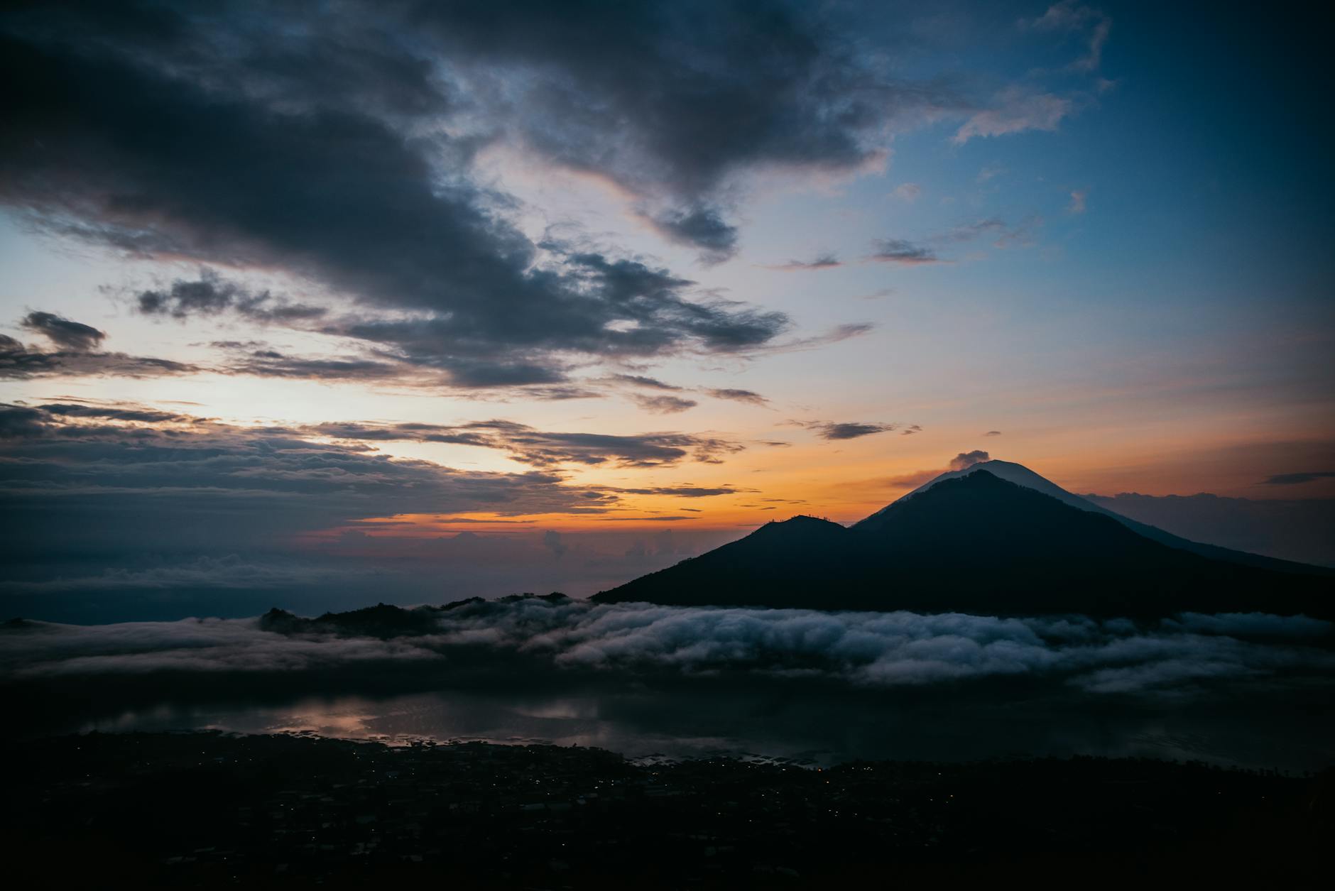 silhouette of mountain above low lying clouds